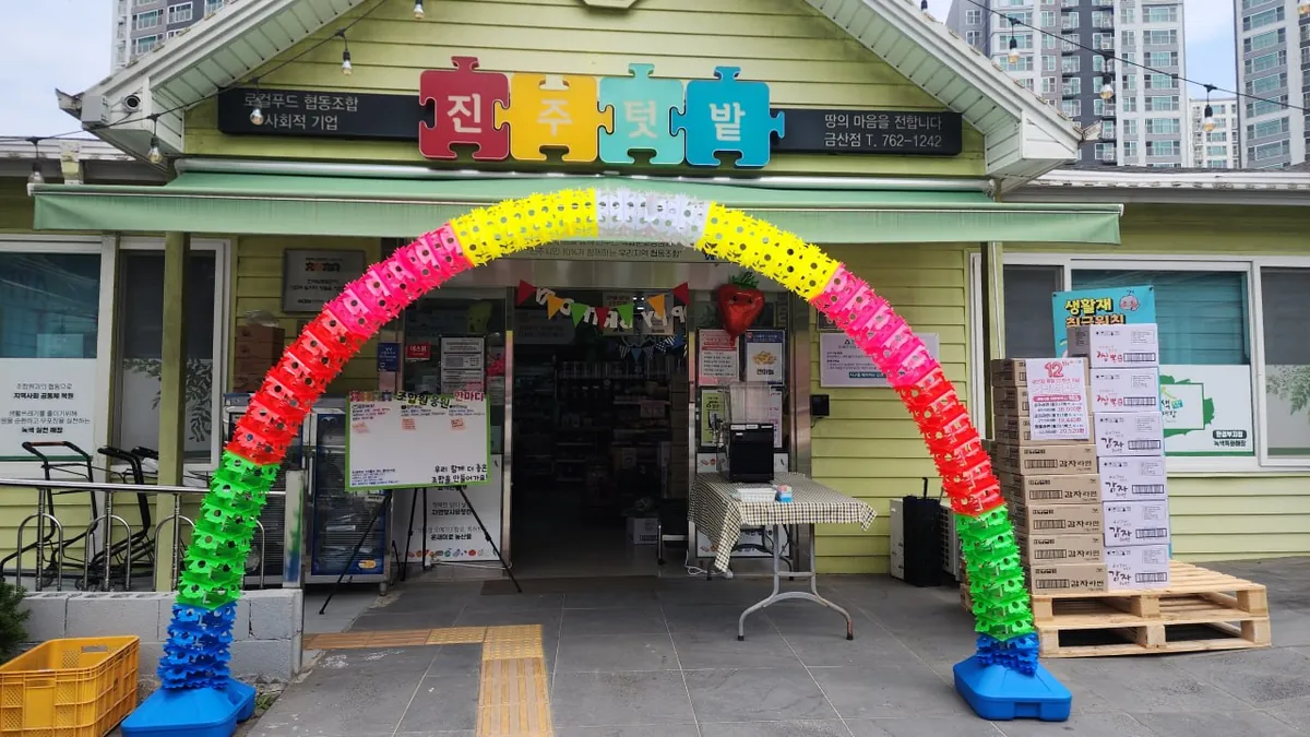 금산점 외관. 노란 목조 건물 입구에 색색의 풍선 아치가 세워져 있다.